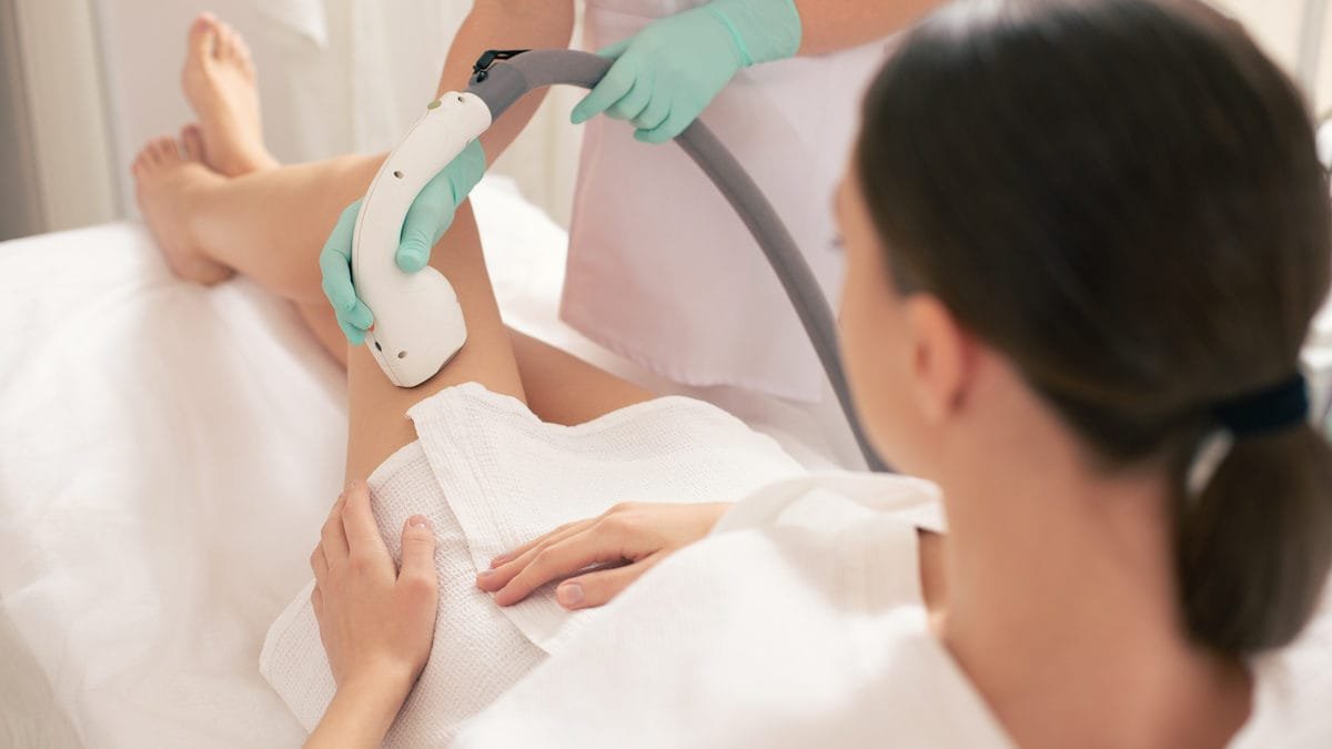 Young woman having laser hair removal on her beautiful legs